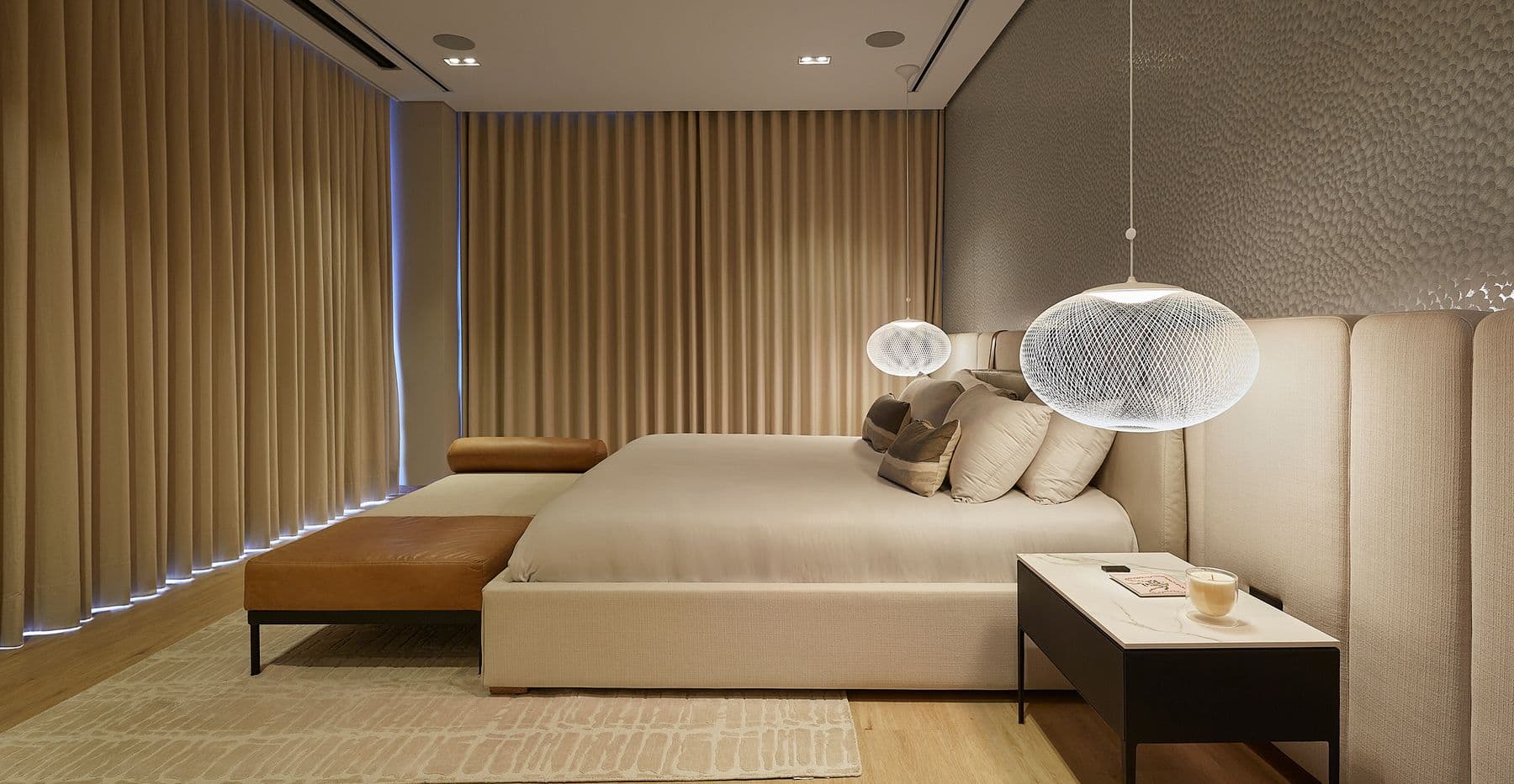 An evening bedroom with floor-to-ceiling drapery closed on two walls