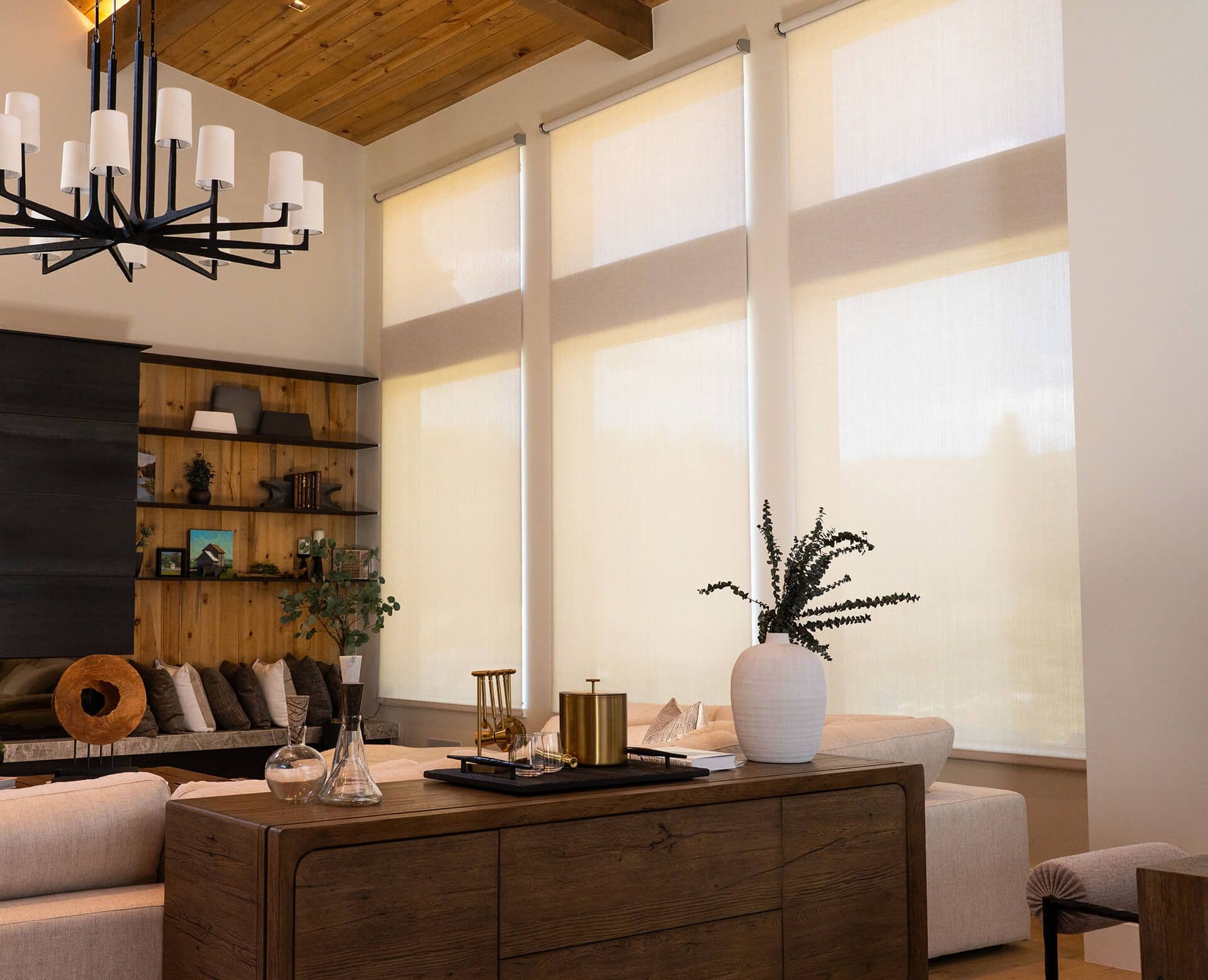 A great room with a cedar ceiling and tall windows, light-filtering shades about half lowered